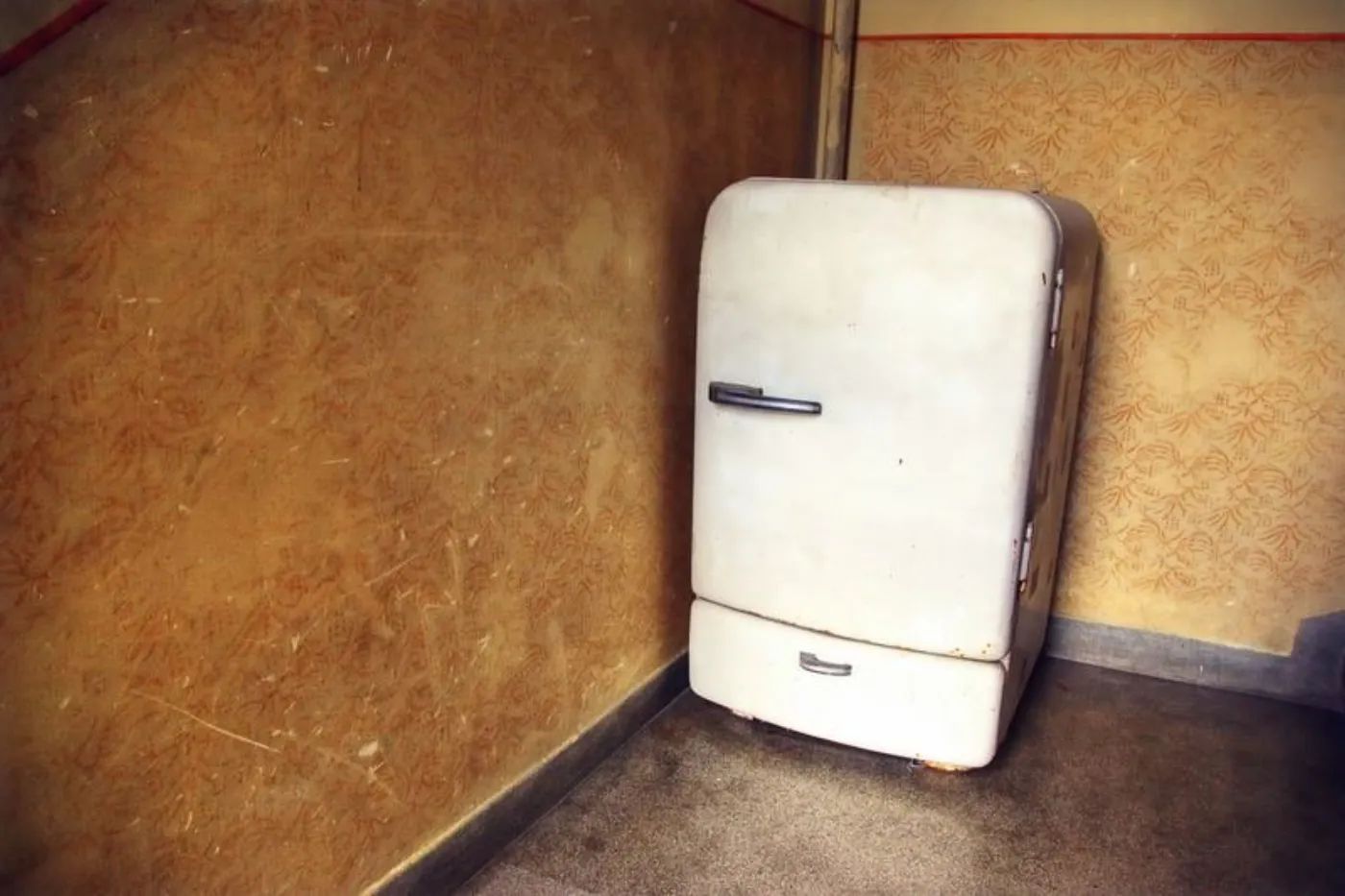 A rusty old white classic-style refrigerator
