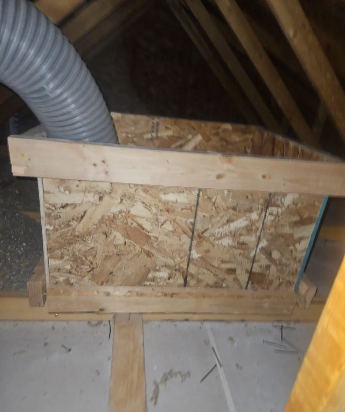 Wood insulation dam built around an attic access in a Longmont home so blown-in insulation stays at full depth