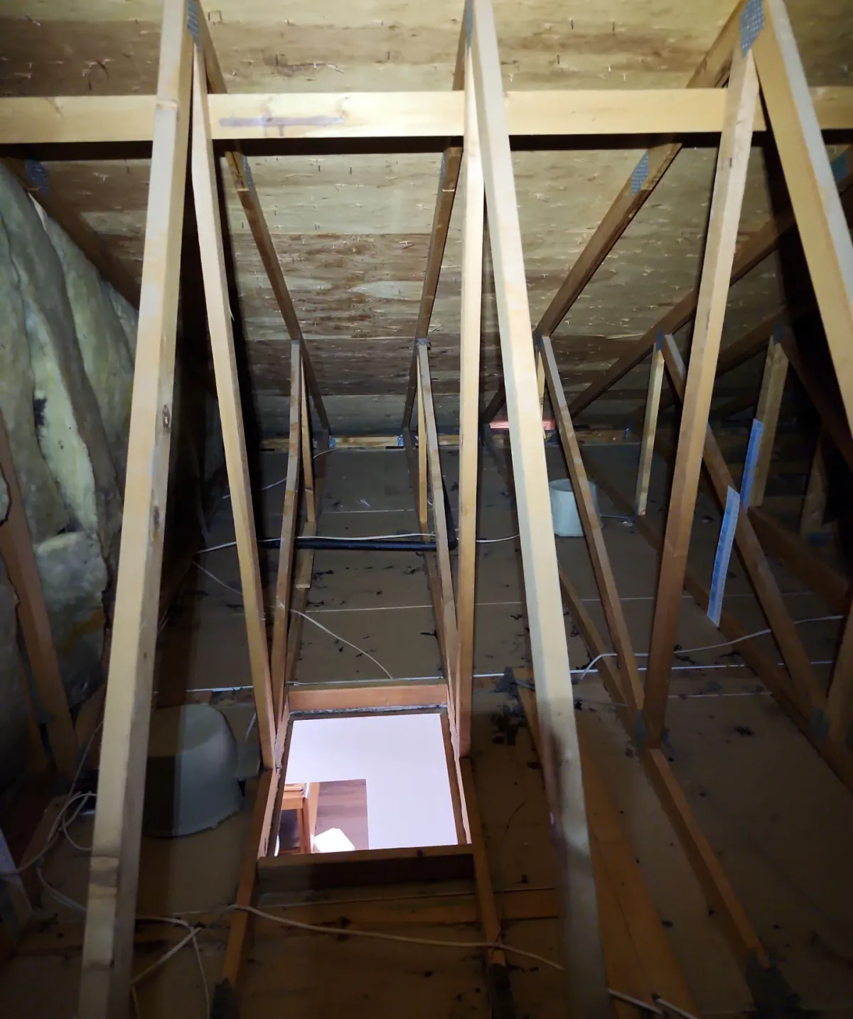 Attic framing exposed after the old insulation was vacuumed out, ahead of air sealing and new blown-in insulation