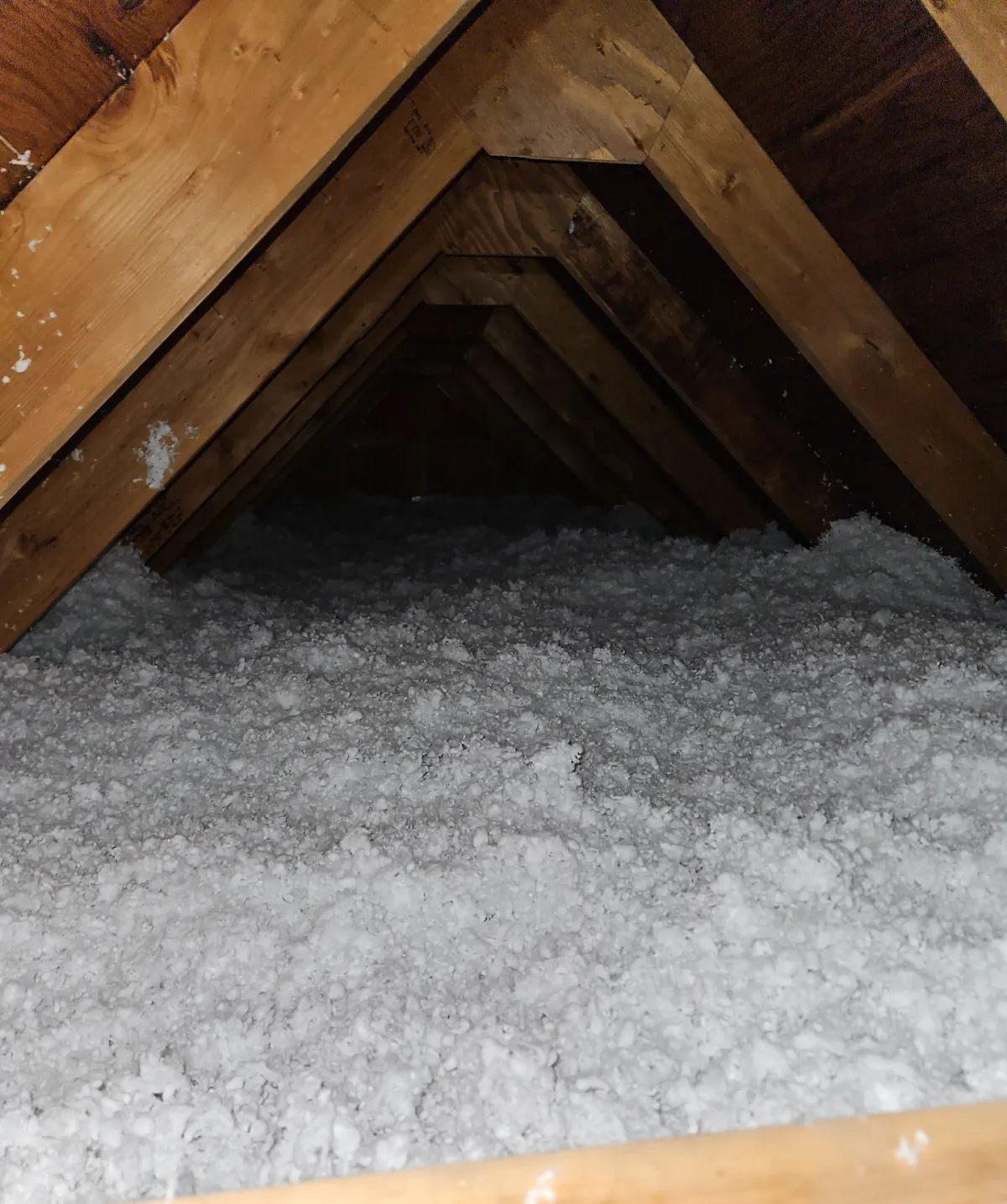Fresh blown-in insulation filling an attic to the rafters in a Longmont home