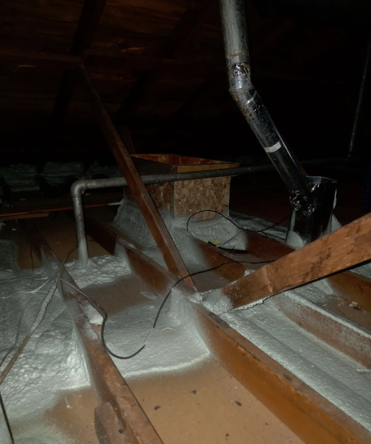 Spray foam sealing the gaps between attic joists and the top plates of interior walls