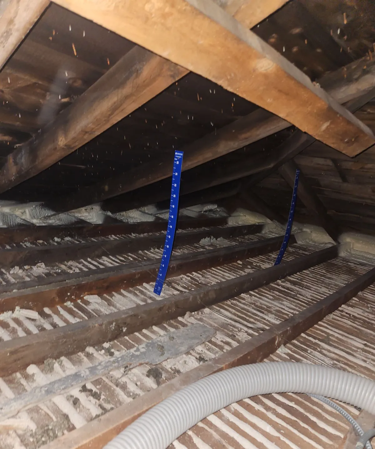Spray foam air sealing along the exterior top plates in a Cheyenne attic before blown-in insulation